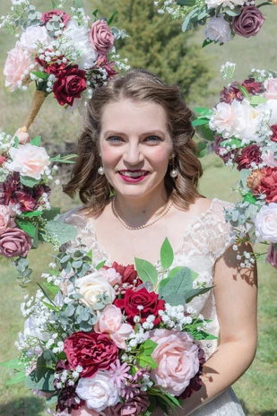 Bride surrounded by her bridesmaids’ flowers at her Omaha wedding