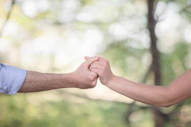 Holding hands to show off an engagement ring, taken by an Omaha wedding photographer