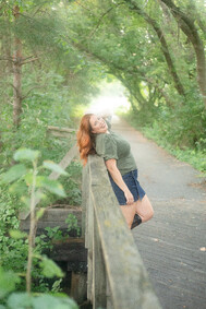 Light & airy portrait of a woman leaning on a bridge in Omaha